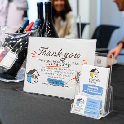 Thank you card and Charlie's House brochures on a table near wine raffle prizes