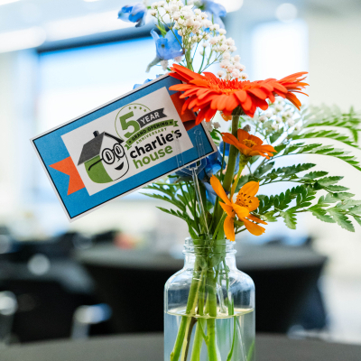 Close-up of a flower centerpiece with a Charlie's House 5 year anniversary tag