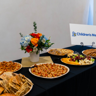 Appetizer table with platters, crackers and a floral centerpiece sponsored by Children's Mercy