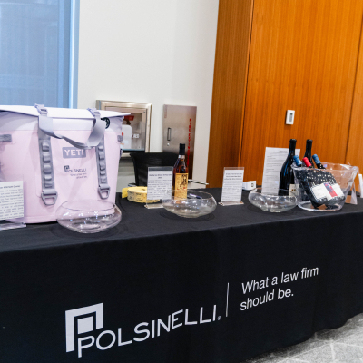 Raffle table with a YETI cooler bag, wine and prizes on a Polsinelli tablecloth