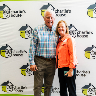 Older couple smiling together at the Charlie's House photo backdrop