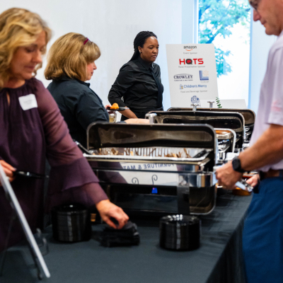 Guests serving food from chafing dishes at the buffet table