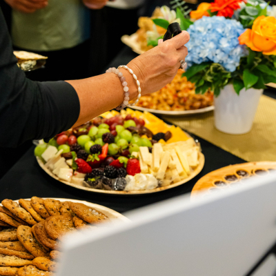Close-up of a fruit, cheese and cookie platter with a floral centerpiece