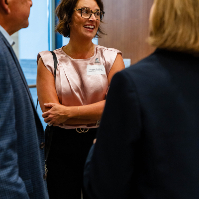 Smiling woman in glasses chatting with guests