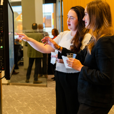 Two young women pointing at the interactive safety display