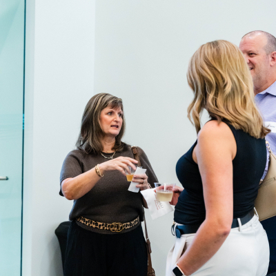 Two women chatting with drinks in hand at the reception