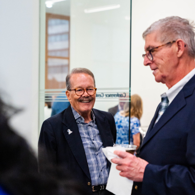 Two older men laughing together at the reception