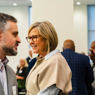 Woman in glasses smiling while talking with a guest