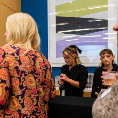 Guests ordering drinks from bartenders at the reception bar