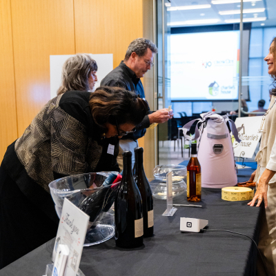 Guests browsing a raffle table with wine bottles and prizes