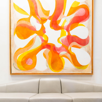 Colorful orange abstract painting hanging above a lounge sofa at the venue