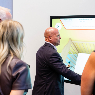 Man using the touchscreen safety display as guests look on