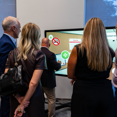 Guests trying the interactive Charlie's House safety display on a touchscreen