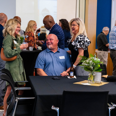 Guests laughing together around a table at the reception