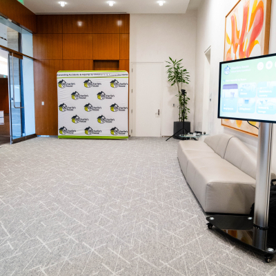 Empty venue lobby with the Charlie's House photo backdrop, safety display and lounge seating