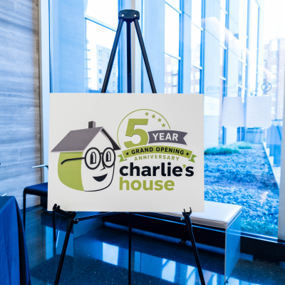 Charlie's House 5 Year Grand Opening Anniversary sign on an easel by the windows
