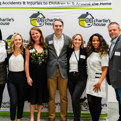 Seven guests smiling together in front of the Preventing Accidents & Injuries banner