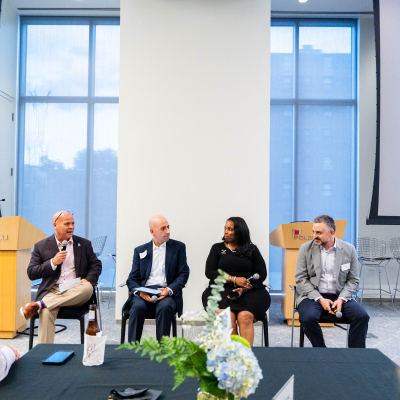 Panelists seated before the audience with a floral centerpiece in the foreground