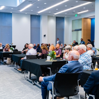 Audience seated at tables throughout the event room during the panel