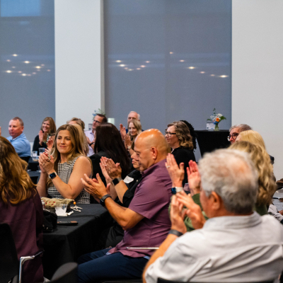 Guests at tables clapping during the anniversary program