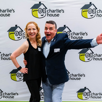Couple striking a playful pose at the Charlie's House photo backdrop