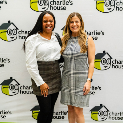Full-length photo of two women at the Charlie's House backdrop