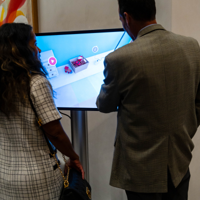 Two guests standing at the touchscreen safety display, seen from behind