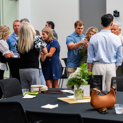 Large group of guests standing and talking around the tables at the reception
