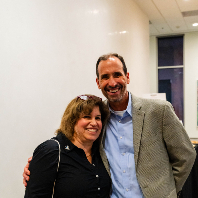 Smiling man and woman posing together at the anniversary event