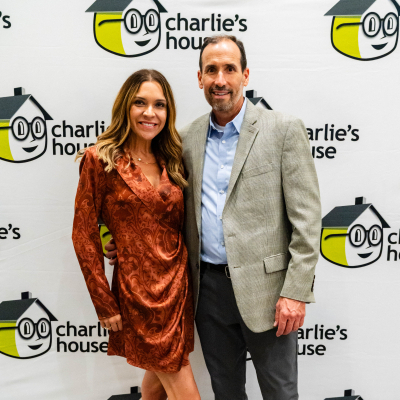 Couple posing in front of the Charlie's House photo backdrop