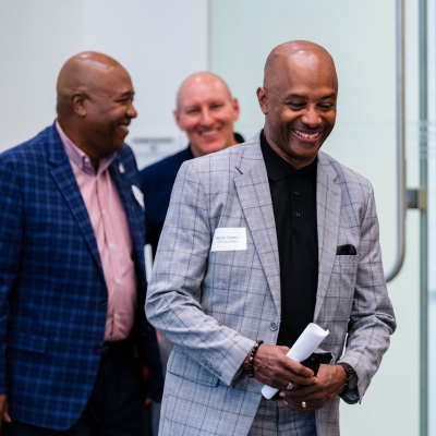 Two men smiling and laughing together at the anniversary event