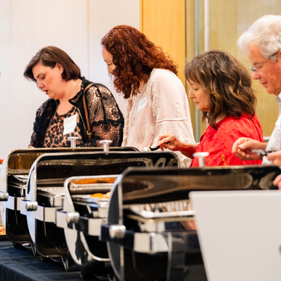 Guests serving themselves from a buffet line of chafing dishes