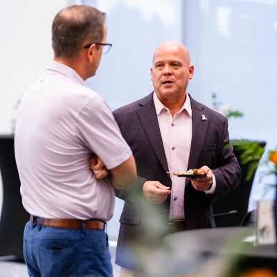 Two men in conversation during the anniversary reception
