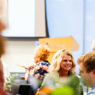 Smiling guest seated at a table during the anniversary event program
