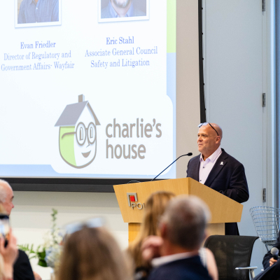 Speaker at the podium with the audience seated in the foreground at the 5 year anniversary event