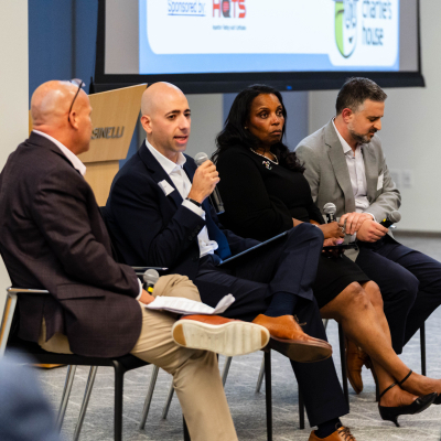 Panel of four speakers seated in a row during the 5 year anniversary event discussion