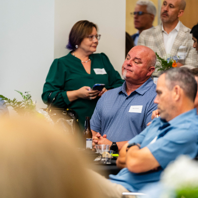 Guests seated around tables during the anniversary program