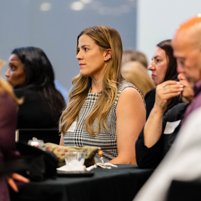 Guests seated at tables listening during the program